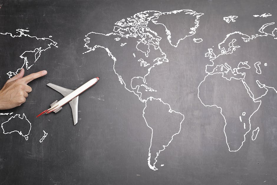 A person holding a world map and pointing at different travel destinations.